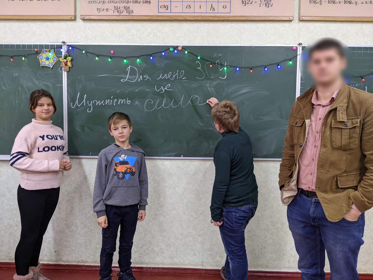 ▲ 전운이 감돌던 2월 중순 한 학생이 교실 칠판에 '우크라이나군은 나에게 용기이고 힘이다'라는 문장을 적고 있다. 학생들 옆에 바실 씨가 서있다. ⓒ 바실 부라소프