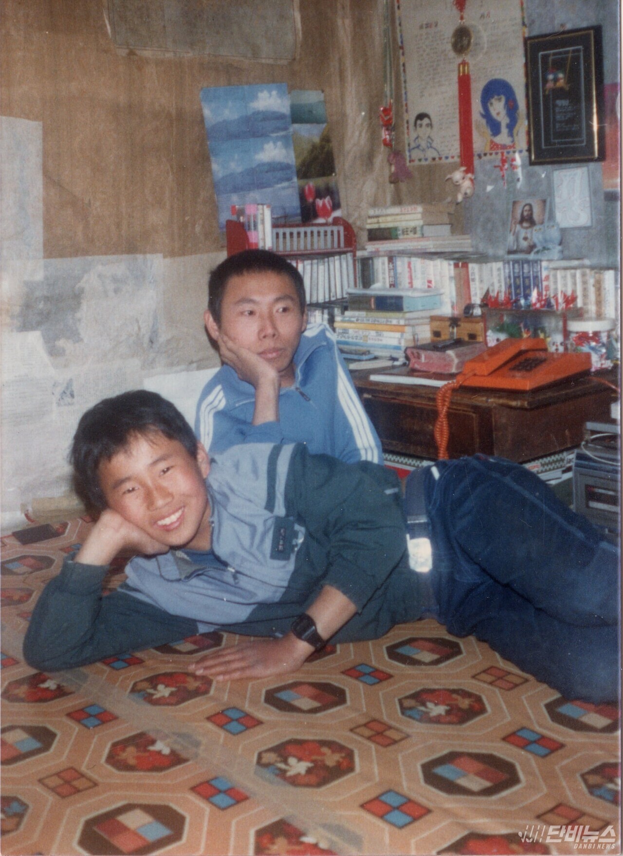 젊은 시절 오문영 센터장(오른쪽)과 막냇동생이 시골집에서 턱을 괴고 웃고 있다. ⓒ 오문영