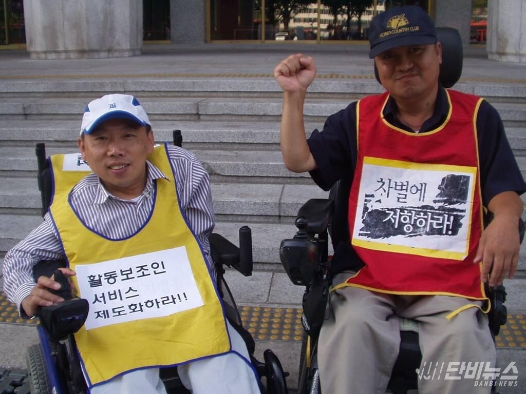 오문영 센터장이 2007년 동료 故김용구와 장애인 권익 옹호 활동을 하며 카메라를 보고 웃고 있다. ⓒ 오문영