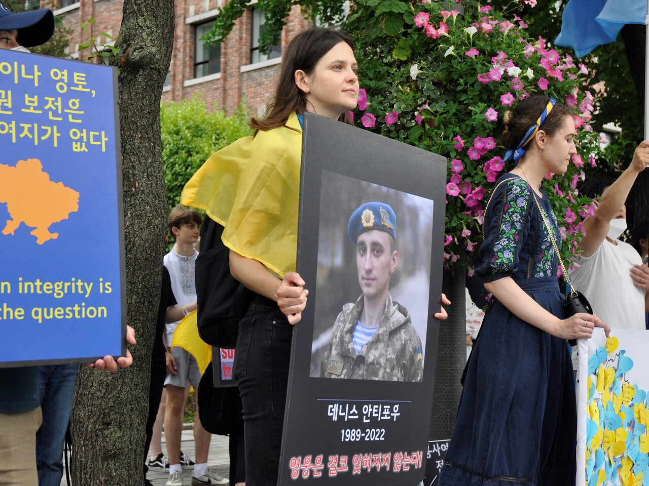 6월 26일 서울 정동교회 앞 집회에서 줄리아 씨가 친구의 사진을 담아 제작한 포스터를 들고 있다. 윤준호 기자