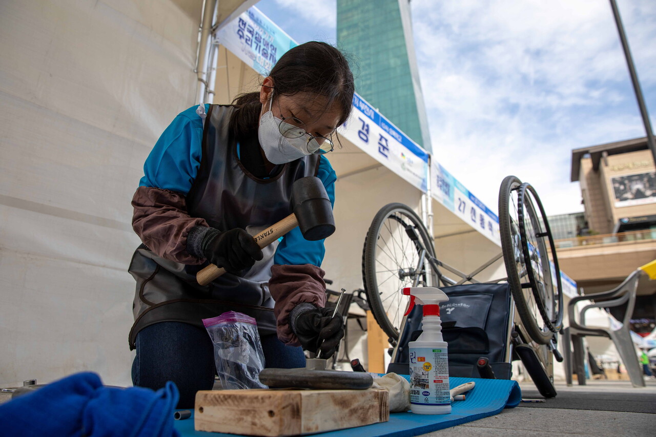 유일한 여성 참가자인 경기 부천시의 김다인(20) 씨가 수동휠체어 앞바퀴에 연결된 베어링을 벗기는 작업을 하고 있다. 박시몬 기자