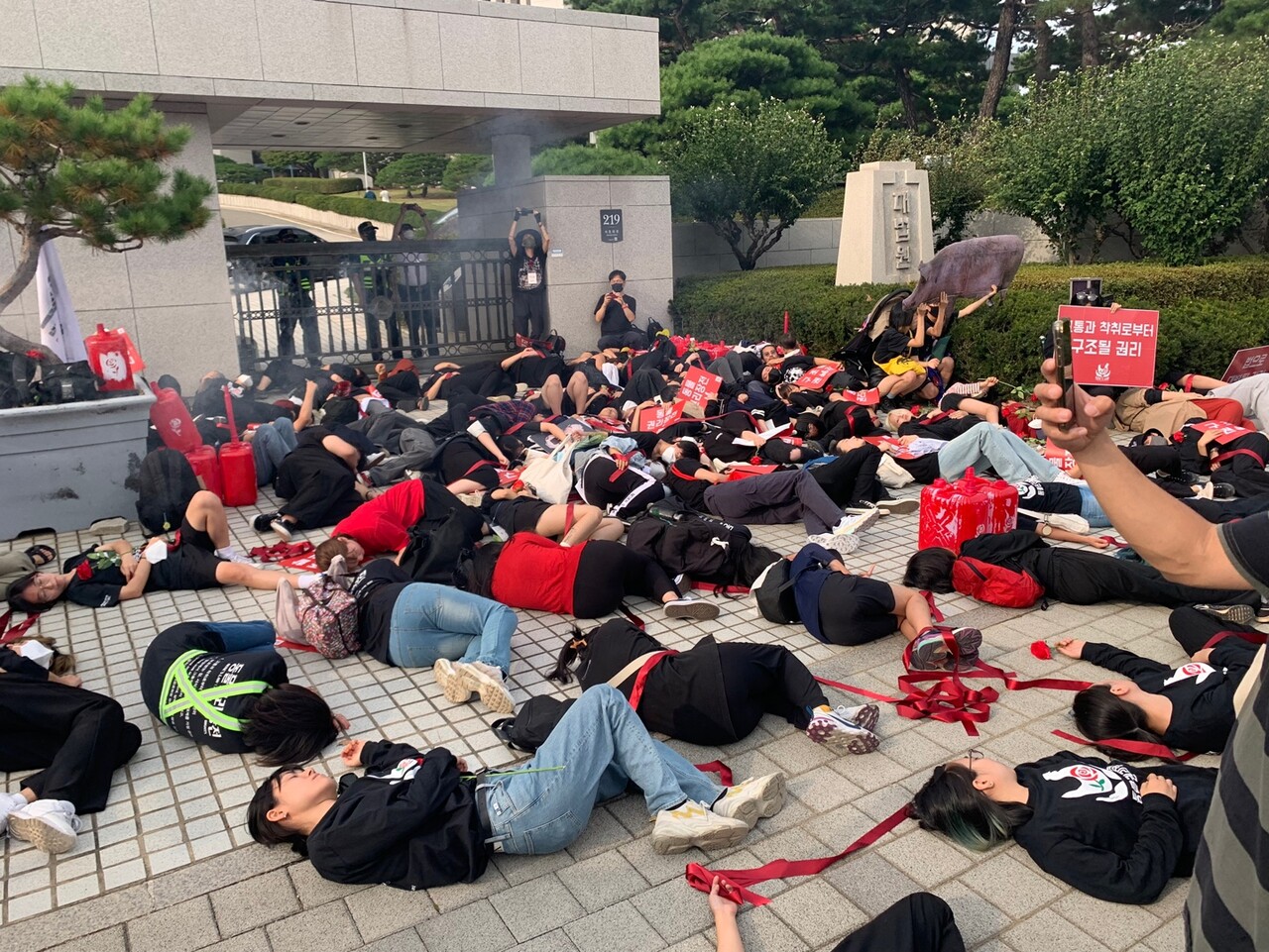1001 동물권리장전행진 참가자들이 서울 서초동 대법원 정문 앞에서 붉은색 끈을 던진 뒤 바닥에 누워 도살장을 재연하고 있다. 목은수 기자
