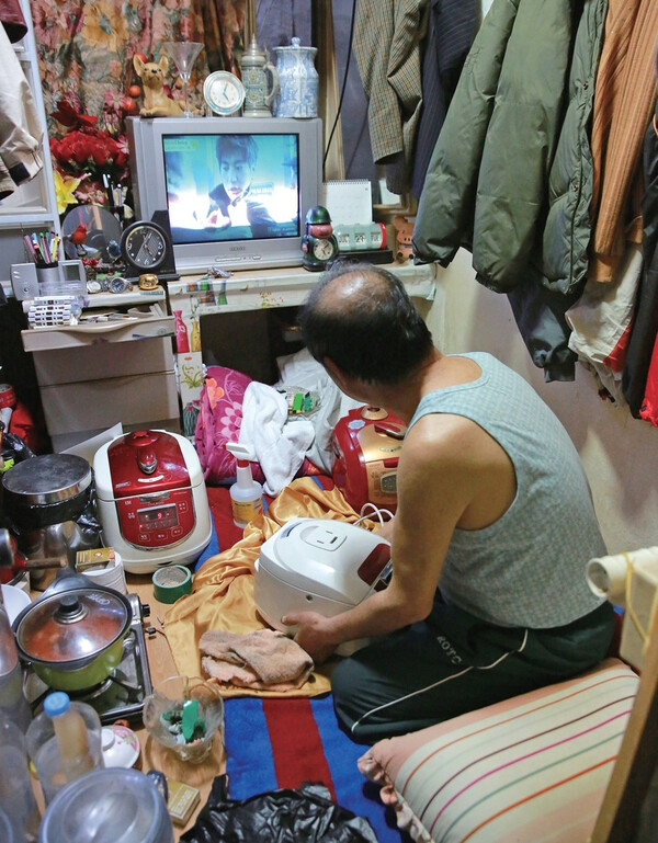 동자동 쪽방촌 주민들은 한 뼘 방에 가득 찬 물건들에 치여 눕거나 앉아서 하루를 보낸다. 출처 한겨레21