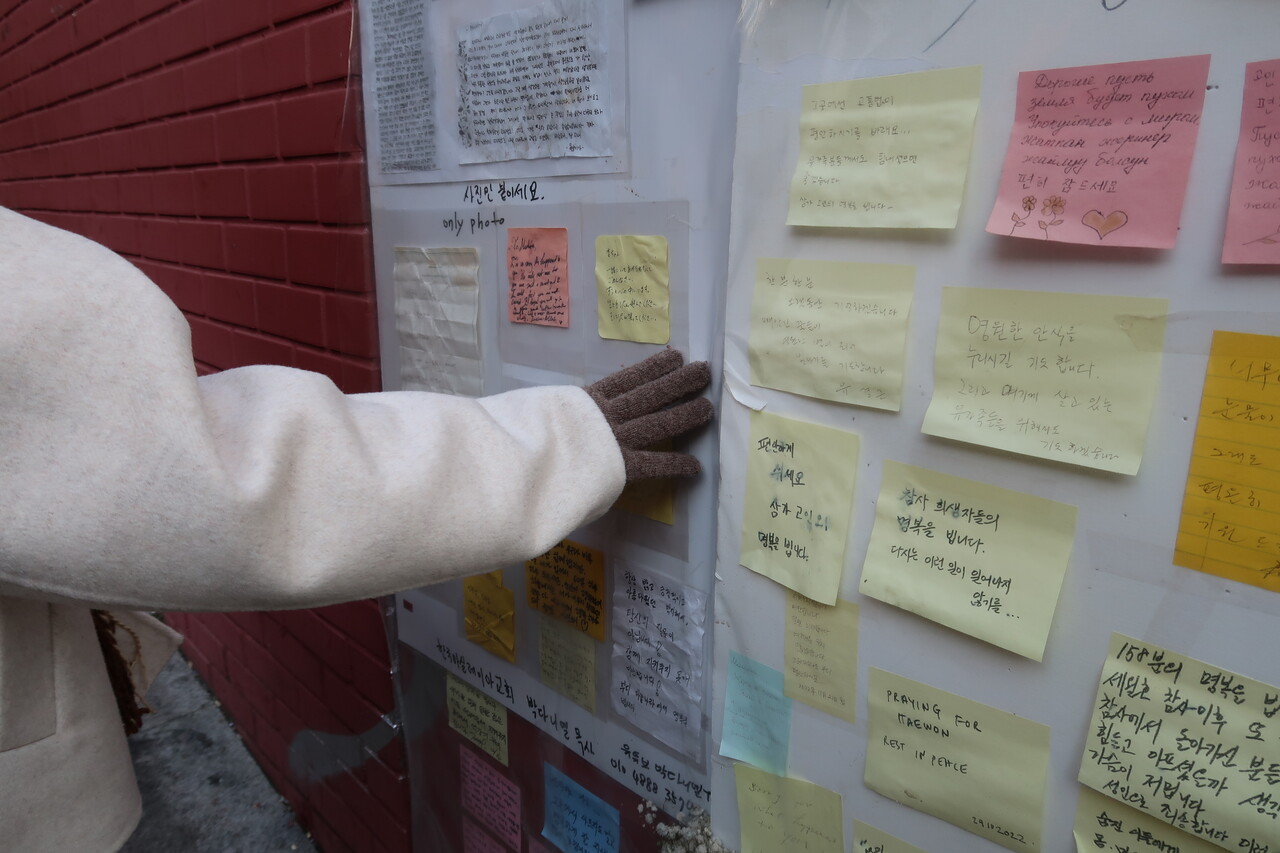 압사 사고가 발생했던 골목의 벽에 붙여진 추모 글을 민아 씨가 읽고 있다. 김지윤 기자