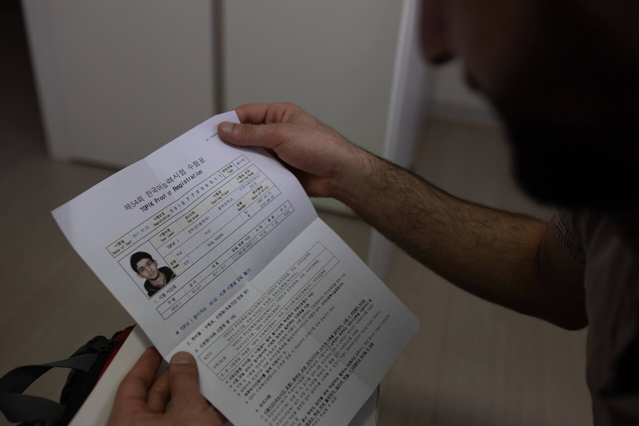 하산이 한국어를 공부하면서 한국어능력시험에 응시할 때의 수험표를 보여주고 있다. 박시몬 기자