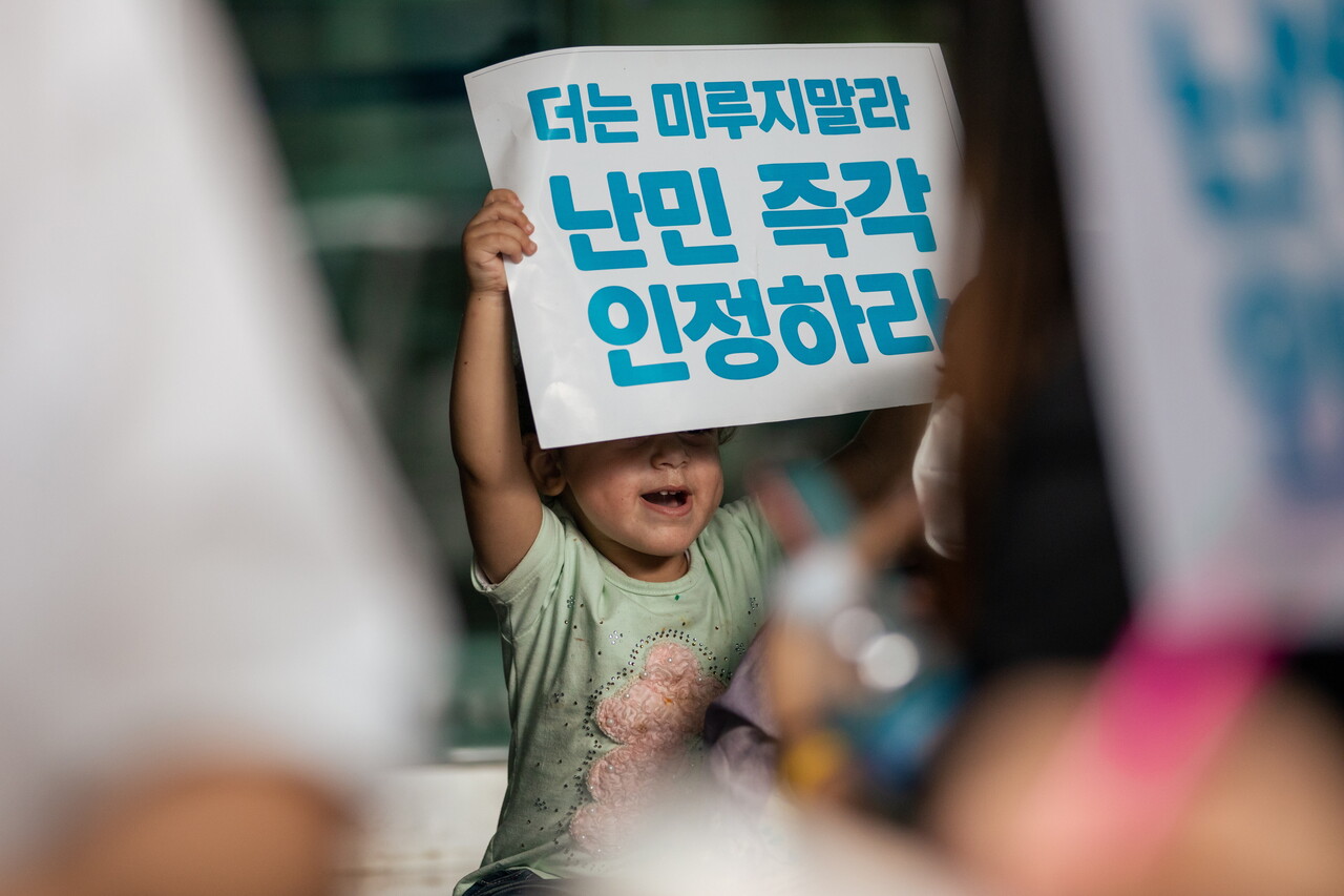 하산의 셋째 딸이 유엔난민기구 한국대표부 앞에서 ‘난민 즉각 인정하라’는 피켓을 들고 구호를 따라 외치고 있다. 박시몬 기자