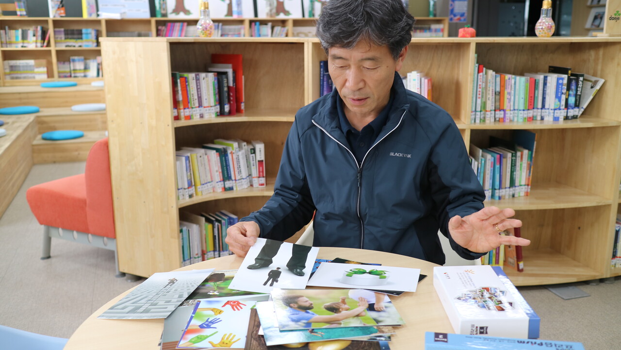 엄재민 교사가 충북 제천 대제중학교 도서관에서 이미지 카드를 보여주고 있다. 이 카드를 이용해 방학마다 하는 글쓰기 기초반 수업에서 글감 찾는 훈련을 한다. 박동주 기자