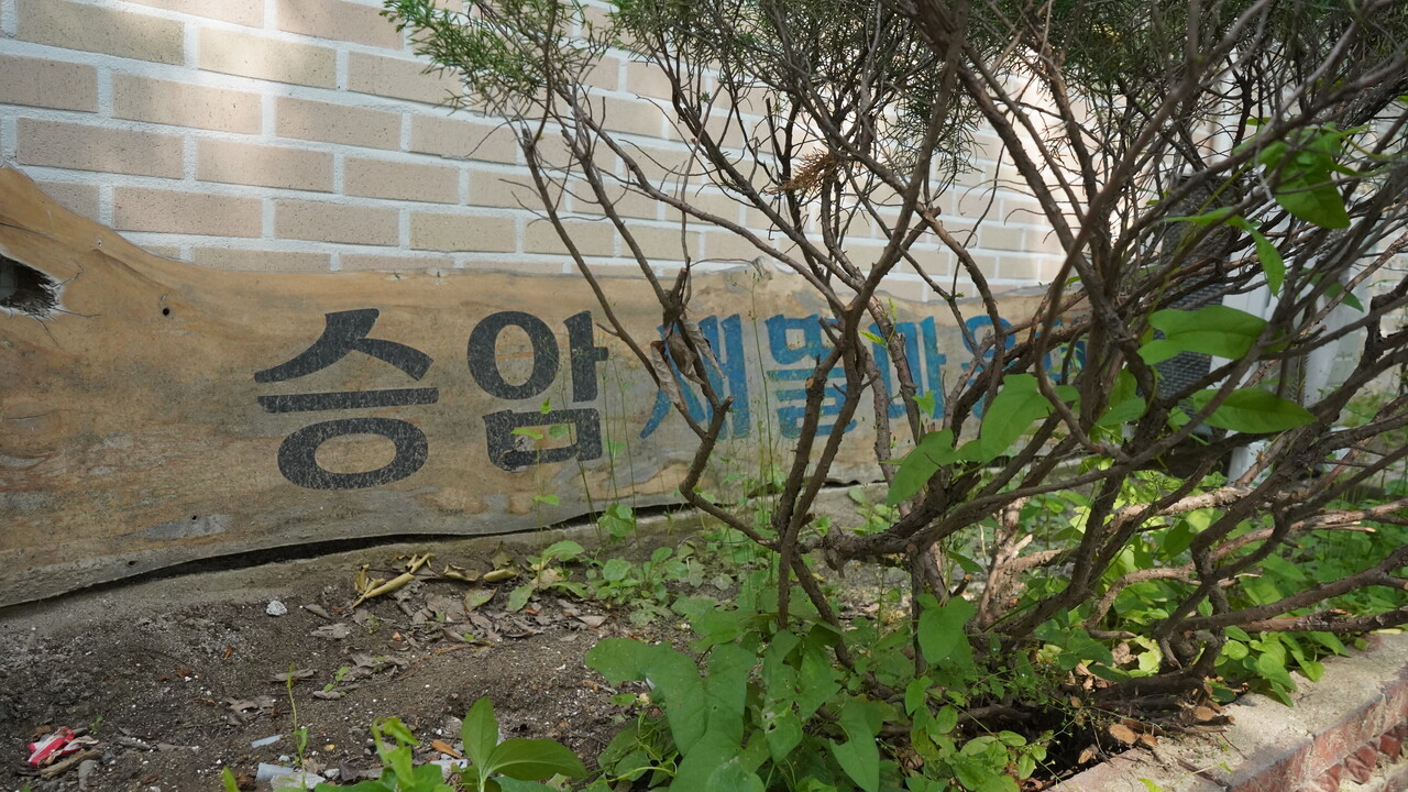 승암 새뜰마을이라는 간판이 바닥에 떨어져 있다. 김대선 기자
