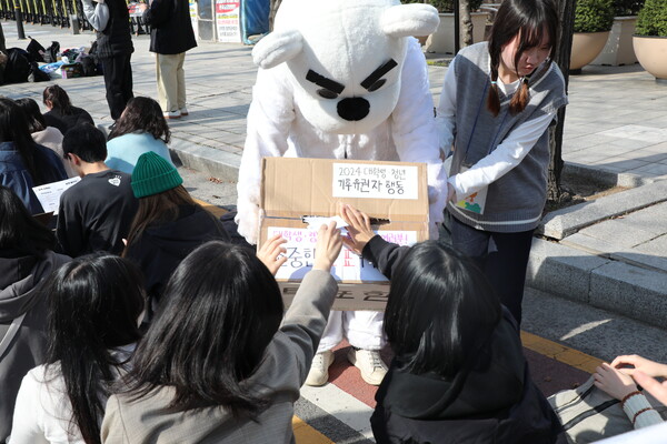 북극곰 분장을 한 활동가가 들고 있는 투표함에 집회 참가자들이 투표용지를 넣고 있다. 곽재화 기자