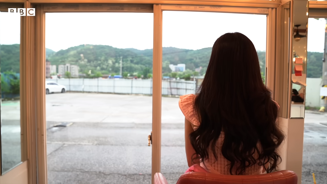 영상 ‘파주의 성매매 집결지, 용주골을 쉽게 떠나지 못하는 사람들’에서 한 성매매 여성이 쇼윈도 밖을 보고 있다. BBC코리아 유튜브 채널 갈무리