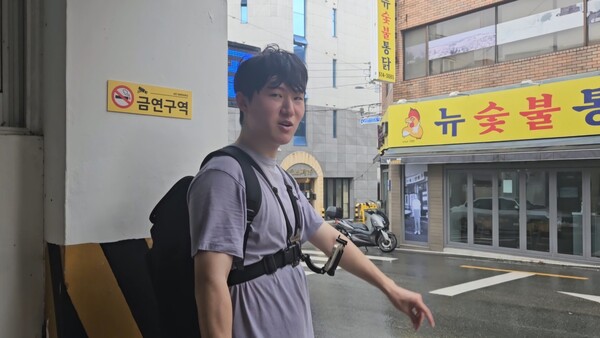 김민성 기자가 갑작스럽게 내린 비에 배달을 중단하고 건물 아래에서 비를 피하고 있다. 하미래 기자