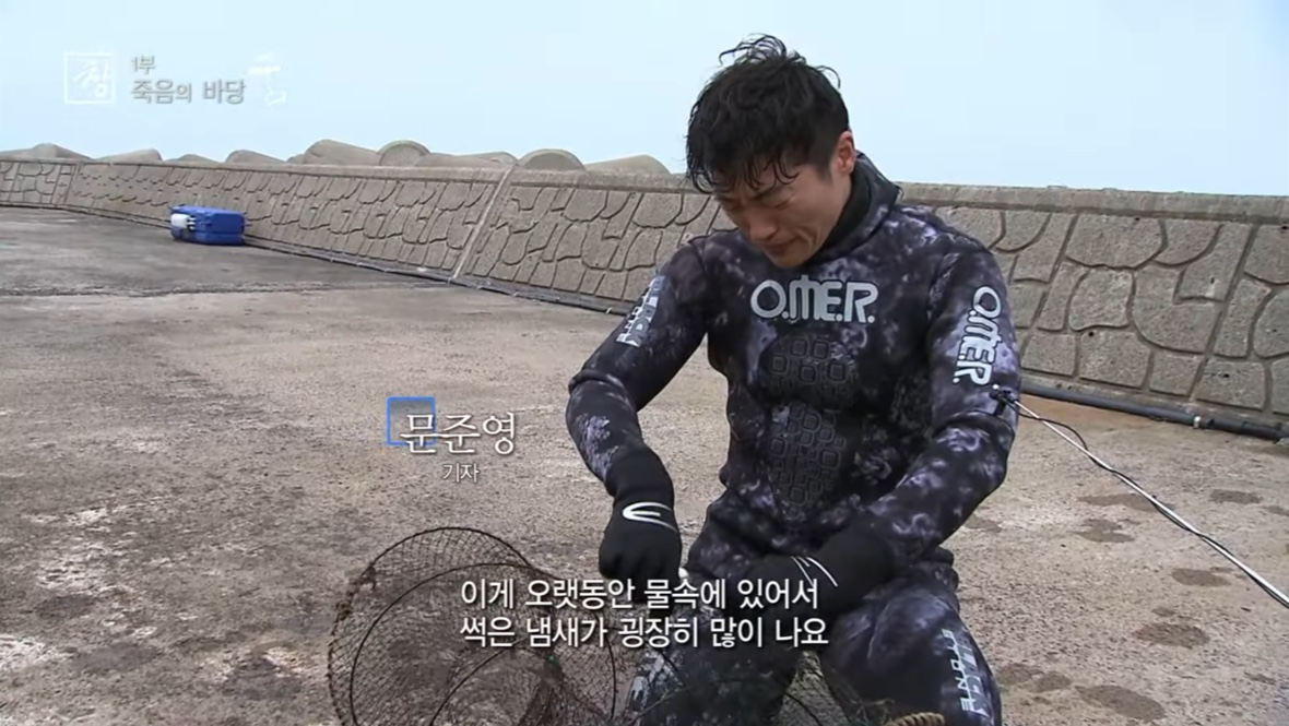 다큐멘터리 ‘죽음의 바당’에서 문준영 기자가 잠수복을 입고 폐어구를 건져 올려 해체하고 있다. KBS 시사기획창 갈무리