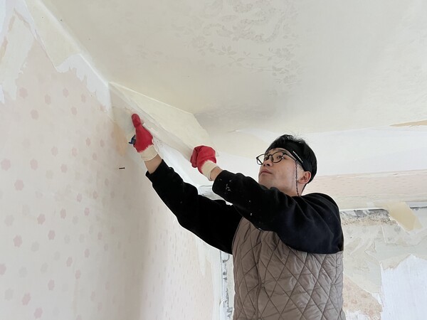 지난해 12월 17일, 전라남도 여수의 한 아파트에서 엄우빈 팀장이 고독사 현장을 청소하고 있다. 집안 곳곳의 냄새를 없애는 약품을 뿌리기 전, 냄새가 배어 있는 벽지를 뜯고 있다. 김예은 기자