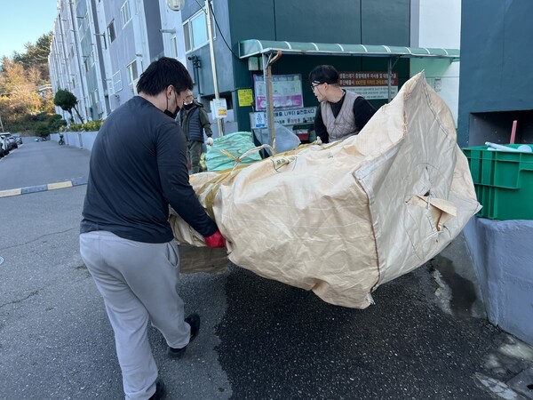 지난해 12월 17일 오후 3시경, 엄 팀장(오른쪽)이 부패한 피가 묻은 침대를 포장하여 동료와 함께 버리고 있다. 김예은 기자