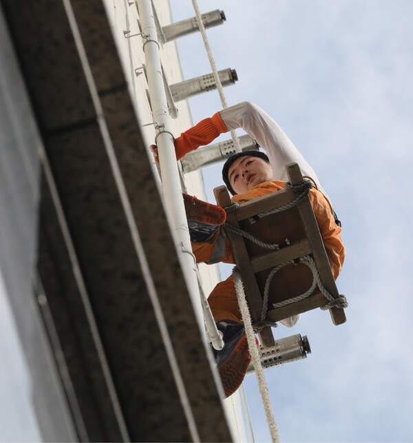 한겨레21 교육 연수생이던 2017년 8월 서울 성동구 아파트에서 윤수현 기자가 외벽 청소 아르바이트를 하고 있다. 윤수현 기자 제공