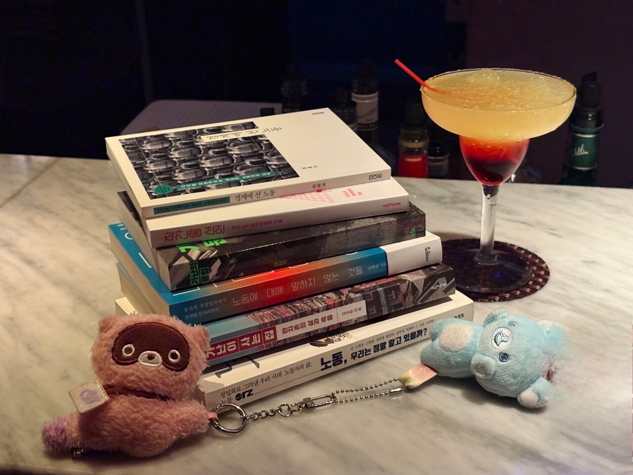 강구현 씨는 얼굴 공개를 사양하며, 대신 자신이 좋아하는 것을 모아 찍은 사진을 보내주었다. 쉬는 날 서점에서 산 노동·빈곤 관련 책 6권과 캐릭터 ‘도구리’와 ‘리락쿠마’, 단골 주점에서 주문한 칵테일 ‘월광’이다. 강구현 제공
