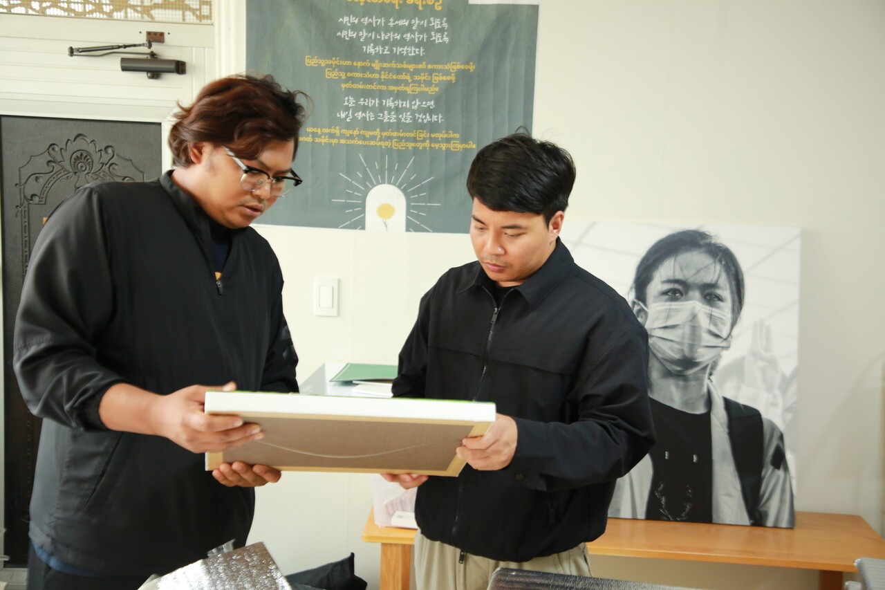 조산(오른쪽) 씨가 ‘승리연합’의 동료와 함께 미얀마 민주화 항쟁 사진전에 전시할 작품을 살펴보고 있다. 손현하 기자
