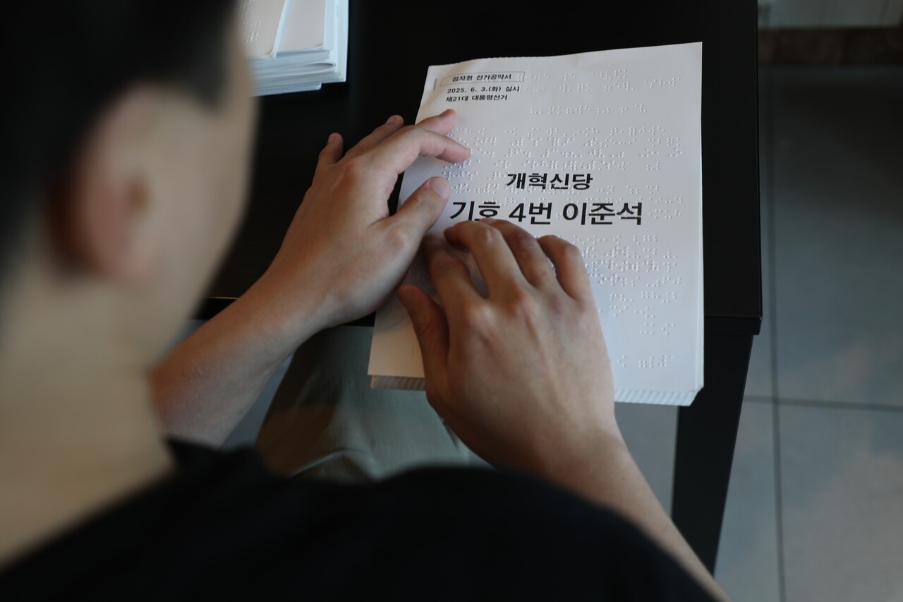 5월 29일 박건우(29) 씨가 충북 청주시 금천동 한 카페에서 개혁신당 이준석 후보의 점자공보물을 읽고 있다. 심은진 PD