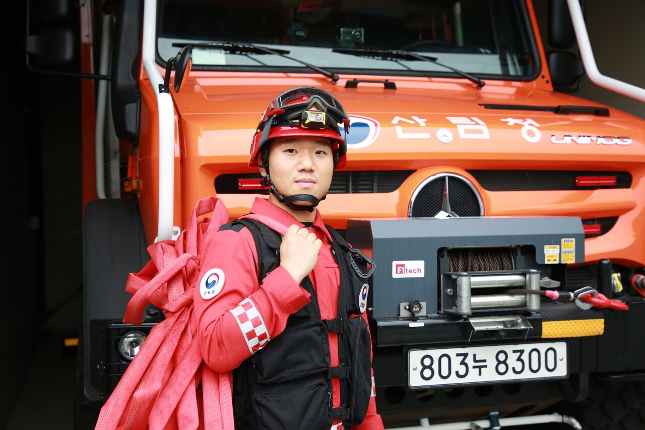 이재성 씨가 산림청 남부지방청 영주국유림관리소가 운용하는 고성능 산불진화차 앞에 서 있다. 개인장비를 모두 착용했고, 산불 진화용 호스를 어깨에 멨다. 김여진 기자