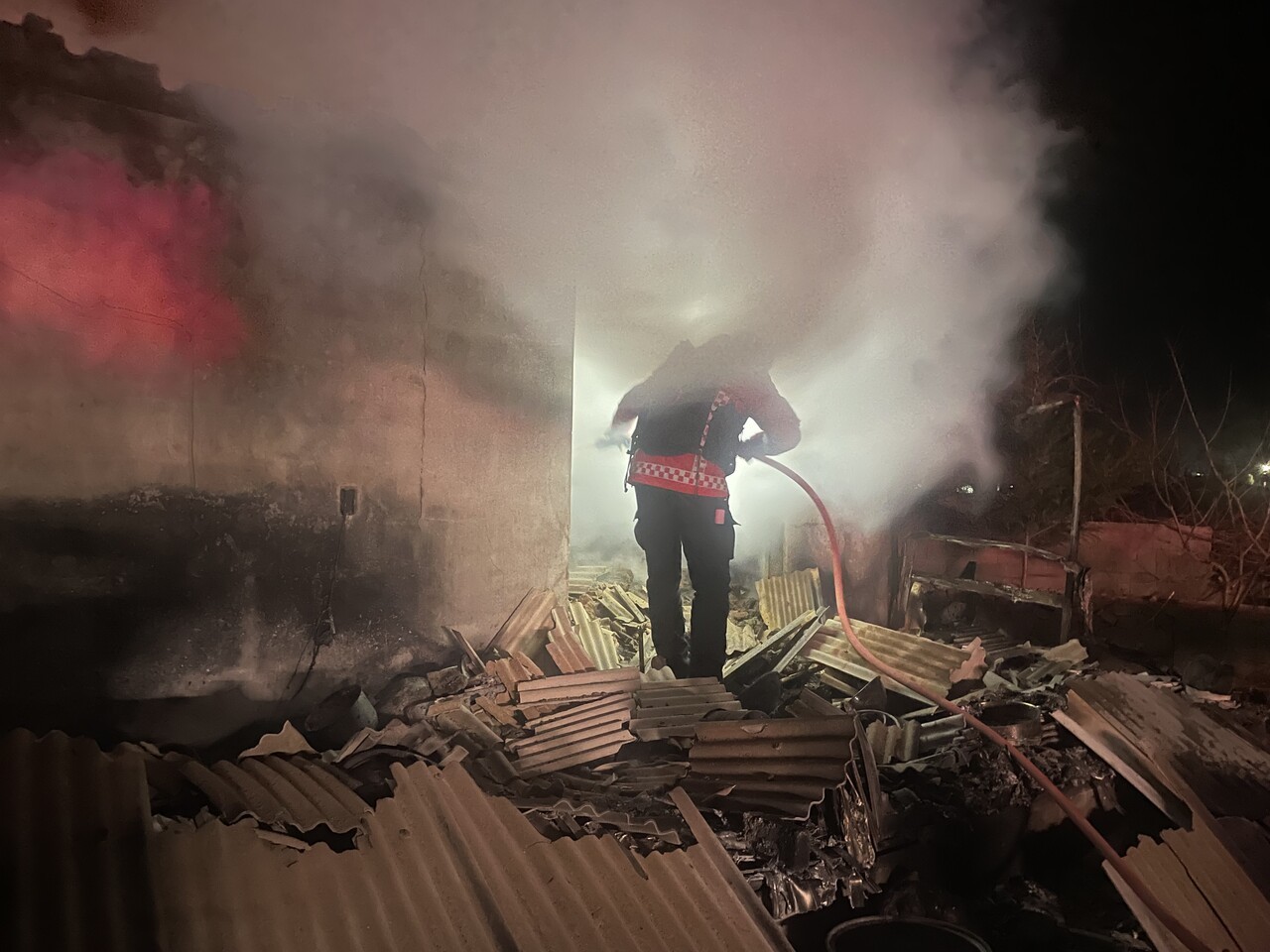 지난 3월 26일 오전 2시, 경북 안동 일직면 운산리의 한 마을에서 산불재난특수진화대원이 민가에 난 불을 끄고 있다. 석면 지붕은 무너져 내렸고, 건물 안에서는 연기가 솟구쳤다. 이재성 씨 제공