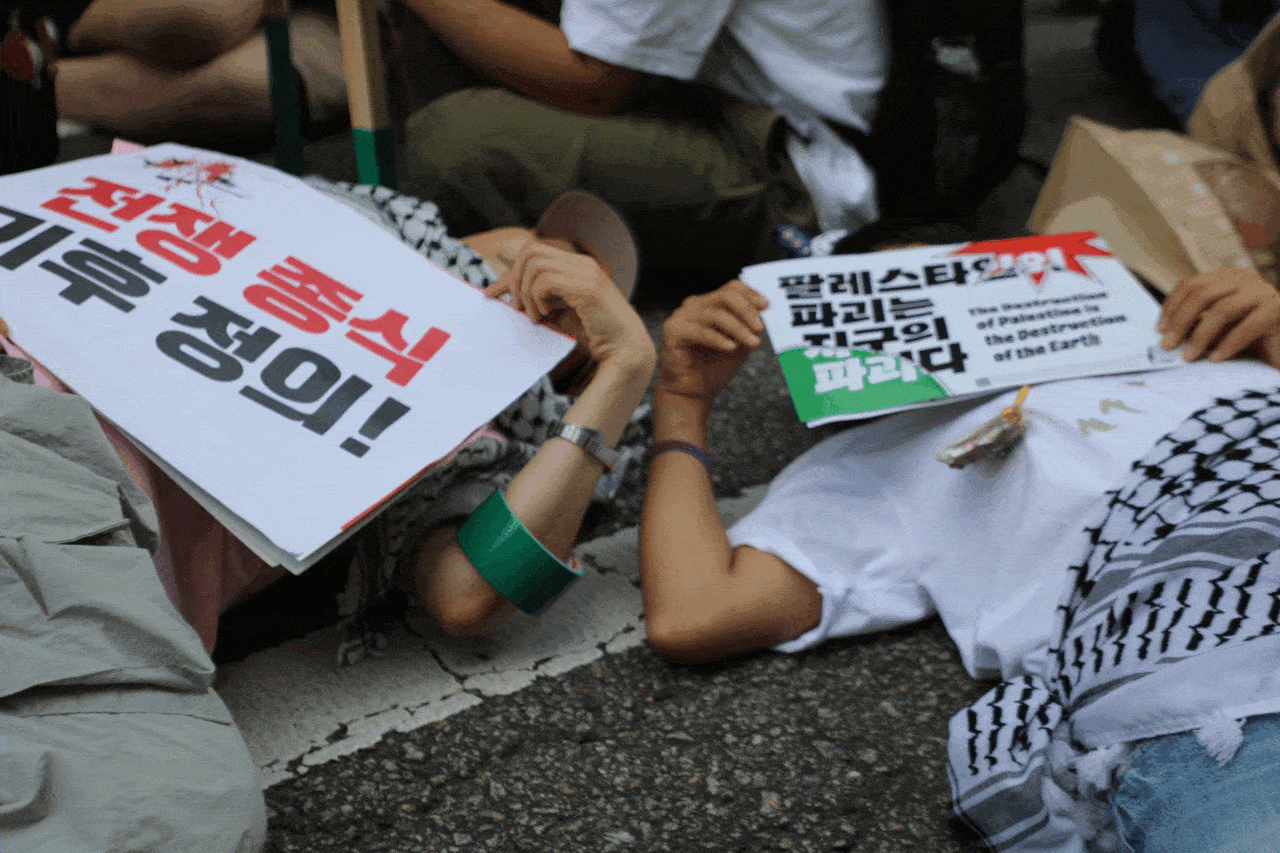 927기후정의행진에 참여한 시민들이 오후 5시가 되자 길바닥에 누워 기후위기 대응과 전쟁 반대 등을 호소하는 ‘다이인’ 침묵시위를 벌이고 있다. 이민기 기자